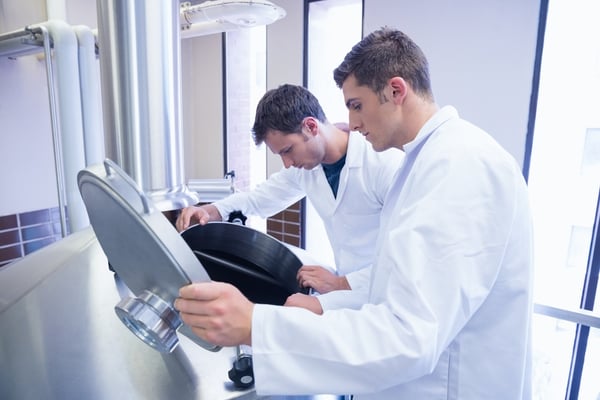 Two scientists looking into the container in the factory